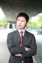 a yong Asiatic businessman  is walking outdoor at night