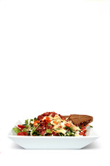 Salat mit Dressing und Speckwürfeln