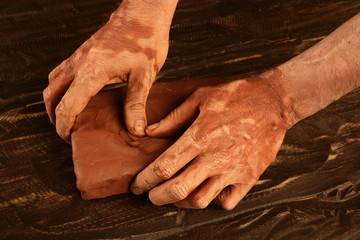 artist man hands working red clay for handcraft