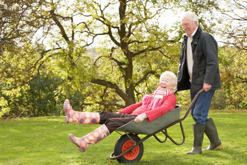 Senior Couple Man Giving Woman Ride In Wheelbarrow