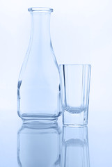 empty transparent decanter and glass for vodka, blue tinted