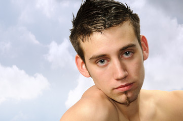 Fototapeta na wymiar sensibler junger Mann Outdoorportrait vor Wolkenhimmel