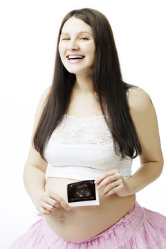Pregnant woman with a photograph of ultrasound.