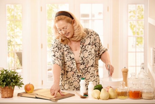 Woman checking recipe in kitchen