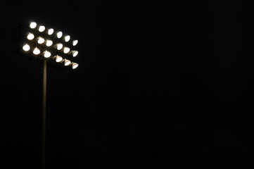 Stadium lights on a sports field at night with copy space