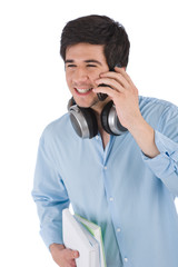 Male student calling with mobile phone holding books