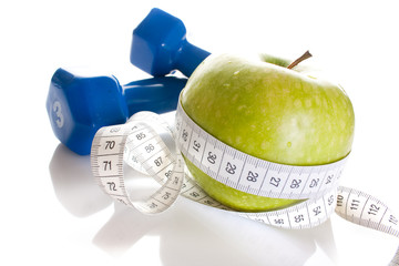 Dumbbells, green apple and measure tape isolated on white