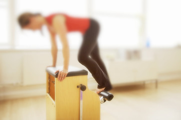 Person using pilates chair in soft focus