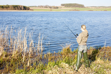 Fototapeta na wymiar woman fishing at a pond