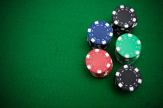 Five stacks of gambling chips on green felt