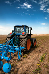 Naklejka premium The Tractor - modern farm equipment in field