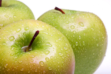 juicy apples in drop of water on white background