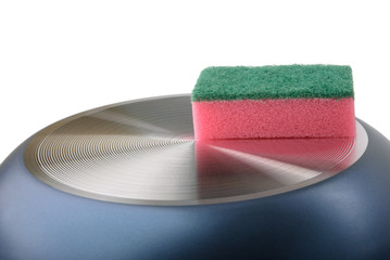 Sponge for ware lies on turned frying pan