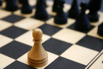 Wood chess game shows white brave pawn challange stronger enemy.