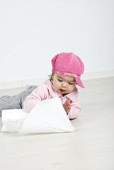 Baby playing with roll of soft paper on floor