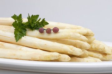 Asperagus white on a plate with herbs