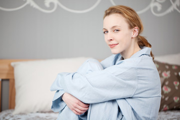 Naklejka premium frau sitzt auf dem bett