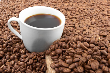 Cup with coffee, costing on coffee grain