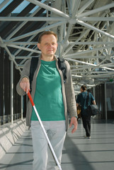 Blinder Mann unterwegs in einem Gebäudekomplex