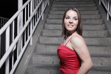 Beautiful young brunette posing by a staircase