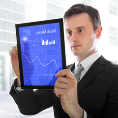 Businessman holding a touchpad pc, checking the stock market