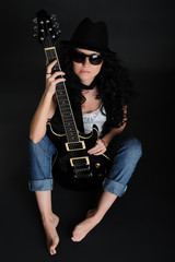 Fototapeta na wymiar Girl sitting on the floor with a guitar