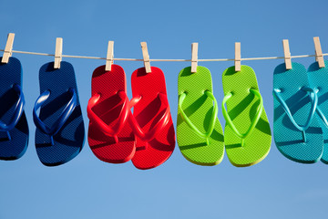 Row of flipflops against a blue sky