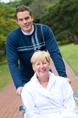 son pushing mother in wheelchair