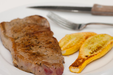 Strip Steak and Grilled Squash on a White Plate