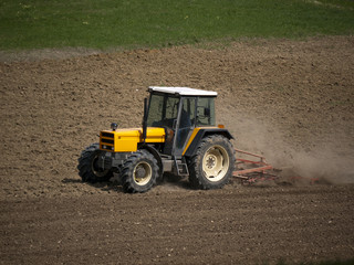 Fototapeta premium Traktor beim Eggen