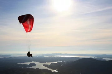 Poster Luchtsport Paraglider die over Noors landschap vliegt