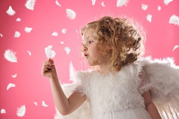 Beautiful angel girl holding a feather