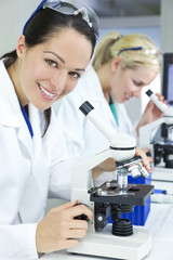 Fototapeta premium Female Scientific Research Team Using Microscopes in Laboratory