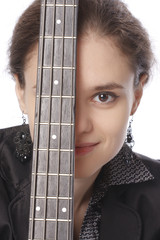 Young woman posing in studio with a black electric bass guitar