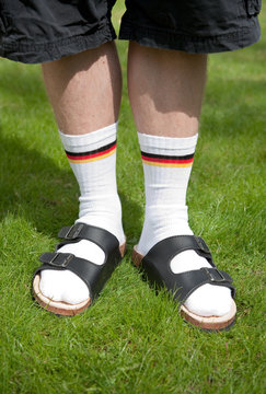 Männerbeine mit Socken und Sandalen