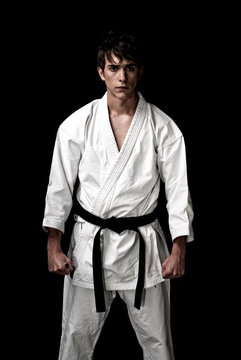 High Contrast karate male fighter on black background.