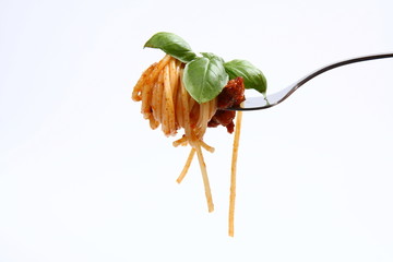 Spaghetti bolognese with basil leaves on a fork
