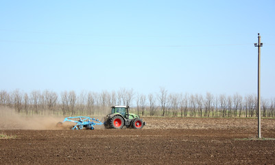 Obraz premium The tractor processes the earth