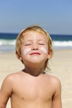 Cute Child With Sunscreen At The Beach