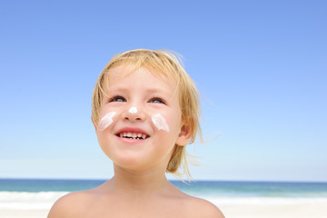 cute child with sunscreen  at the beach