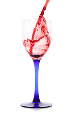 Red wine flowing to a glass. Isolated on white