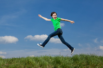 Girl jumping, running against blue sky