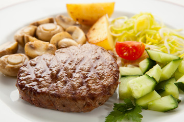 Grilled steaks with chips and vegetables