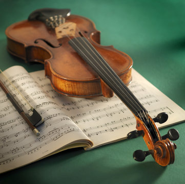 violin with sheet music and bow