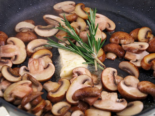 cooking brown champignon, butter & herb in black pan