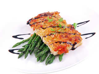 baked fish with green asparagus on white background