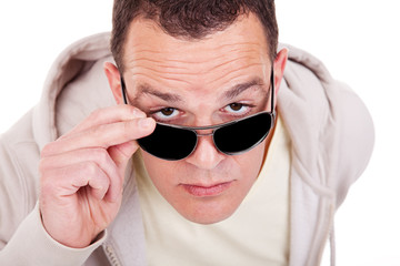 portrait of a young adult man looking over his sunglasses