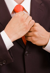 Detail of young businessman correcting a tie