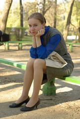 a tired girl sitting on a bench