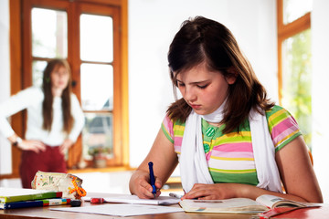 teennager girl doing homework getting stressed by her mom